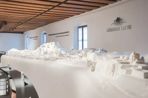 Detailliertes weißes 3D-Stadtmodell in einem Museum mit Holzdecke und gebogenen Ausstellungsflächen